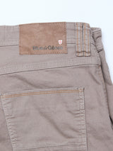 Close-up of the back of Blue de Gênes Paulo Pavia 1 V2 Chino - Fungi, showing a brown leather waistband patch with the brand name and red and white shield logo. Part of the back pocket is also visible.