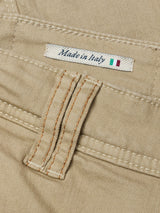 Close-up of Blue de GĂȘnes Paulo Pavia 1 V2 Chino - Khaki in stretch cotton, showing a stitched Made in Italy label next to the Italian flag and a belt loop with orange stitching.