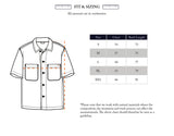 Illustration of the BGforma Onda S/S Shirt - Blue Pattern by Blue de Gênes, an oversized cotton short-sleeve shirt with two front pockets and a tribal design. Size chart (S–XXL, chest & back length in cm) and notes on natural material variations included.