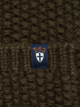 A close-up of a textured dark brown knit fabric from the Blue de GĂȘnes Aimone Knit Cardigan - Army, with a navy label displaying a white shield and orange 88g text.