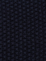 Close-up of the Aimone Knit Cardigan by Blue de Gênes, showcasing its dark navy, waffle weave pattern with a grid-like texture reminiscent of coarse pearl knit, offering a feel akin to luxurious lambswool.
