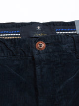 Close-up of Albi Cargo Pant - Dark Navy by Blue de Gênes featuring a brown button with THE STYLING NED RONNING, zip closure, and a loose fit waistband with blue, white, and beige stripes. Clothing label is also visible.