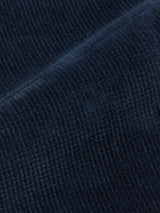 The Albi Cargo Pant in Dark Navy by Blue de Gênes showcases a textured, ribbed pattern with diagonal lines that enhance the soft, velvety surface typical of corduroy, embodying the cross-cord comfort quality often found in loose-fit designs.