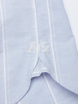 A close-up of the Basso Hackney Shirt by Blue de Gênes shows blue and white stripes with a white embroidered BKG monogram near the hem, exuding a personalized touch.