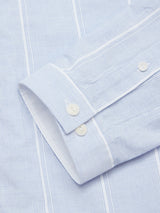The Basso Hackney Shirt by Blue de Gênes features a close-up of its cotton sleeve, showcasing blue and white vertical stripes that enhance its classic design. The buttoned cuff and subtle logo embroidery add elegance to this timeless garment.