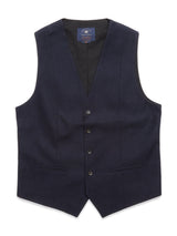 The Canna Carbonio Gillet by Blue de Gênes is a dark navy mens formal vest made from Italian brushed cotton. It has a V-neck, five buffalo horn buttons, two pockets, and an adjustable strap for a tailored fit, providing a smooth and polished appearance.