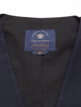 Close-up of the Canna Carbonio Gillet - Dark Navy by Blue de Gênes, crafted from Italian brushed cotton. The label under the collar displays decorative text and a cross emblem with 50 below. An adjustable strap and Buffalo horn buttons enhance its charm and the fabrics subtle texture.