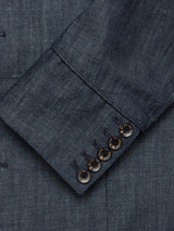 Close-up of a denim blue Casella Wasabi Blazer sleeve by Blue de Gênes, showcasing the shiny buffalo horn buttons arranged near the cuff. The visible texture of the dry denim fabric is reminiscent of an elegant Officers Blazer.