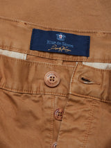 Close-up of Franco Genes Chino - Biscotto featuring a button fly. The garment-dyed fabric is textured with neat stitching on the buttonholes. A blue label on the waistband displays Blue de Gênes, adding distinction to this Saia twill piece.