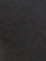 Close-up of the Franco Genes Chino in Charcoal by Blue de Gênes, featuring a garment-dyed black fabric with a diagonal twill weave and fine ridges reminiscent of Saia twill for a subtle striped look.