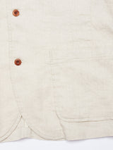 Close-up of the Gabbiano Winnot Blazer - Natural by Blue de Gênes, showcasing its beige cotton linen with visible texture and wooden buttons. Features include a right-side pocket, highlighting its natural weave for a relaxed blazer look.