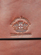 Close-up of embossed premium bull leather with Progetto Heritage and Blue de Gênes above and below a crest with two lions flanking a shield. The BDG Leather Journal - Brown exudes vintage charm, featuring a black cord at the bottom for added elegance.