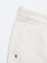 Close-up of the top section of Blue de Gênes BGpalco Twill Pants in Chalk, featuring relaxed fit light beige cotton twill, waistband, front pocket, and a small metallic accent near the pocket on a white background.