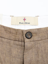 Close-up of the waistband of grey melange BGpalco Lin Pants by Blue de Gênes, showing a black button and a “Blue de Gênes” label with a red and white shield logo above the brand name.