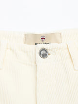 Close-up of the waistband on BGfloyd Cord Shorts - Chalk by Blue de Gênes, showing a tree-engraved metal button and a red and white Blue & Ganoe shield label. Made from soft cotton corduroy for a loose, comfortable fit.