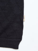A close-up of Blue de Gênes' BGwally Diamond Polo in dark navy, showing its quilted diamond knit texture and a small beige logo tag on the right, set against a white background.