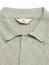 Close-up of the BGwally Diamond Polo in Shadow Green by Blue de Gênes, featuring a diamond-knit pattern, pale green buttons, and brand tag inside the collar. Made from a breathable cotton-linen blend for comfort.
