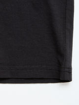 Close-up of the bottom hem of a Blue de Gênes BGoscar T-Shirt in Jet Black, made from 100% cotton, highlighting stitching details and fabric texture against a white background.