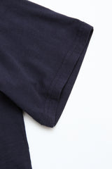 Close-up of the short sleeve and shoulder of a BGoscar T-Shirt - Dark Navy by Blue de Gênes, showing its classic crewneck design, laid flat on a white surface.