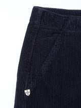 Close-up of the BGfloyd Cord Shorts - Dark Navy by Blue de Gênes, highlighting a side pocket accented with a small metallic shield-shaped emblem near the seam.