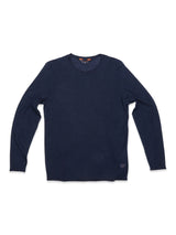 The Monte Knit - Navy by Blue de Gênes is a dark navy blue crewneck jumper on a white backdrop, showcasing a long-sleeve knit design with a round neckline and roll-rib hem. Crafted from a cotton/linen blend, it features a simple, classic look.