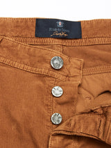 Close-up of Blue de Gênes Paulo Tucan Chino in Biscotto, showcasing a partially open button fly with three silver buttons. A dark label on the waistband highlights its Italian craftsmanship, with fabric texture and stitching details clearly visible.