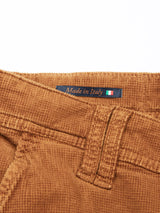 The Paulo Tucan Chino - Biscotto by Blue de Gênes is crafted from brown comfort stretch corduroy fabric with a waistline and belt loop. A small tag above, marked with the Italian flag, declares Made in Italy, showcasing its heritage as regular fit jeans.