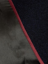 Close-up of a fabric edge showing two textures: smooth, shiny olive green on one side and dark matte Melton wool on the other, bordered by a thin red line, evoking classic peacoat style from Blue de Gênes Peacoat - Dark Navy.