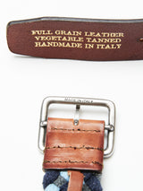 A close-up of a blue Pratese Belt by Blue de Gênes shows its exquisite craftsmanship, featuring a metal buckle engraved with Made in Italy. Handmade from vegetable tanned, full grain bull leather.