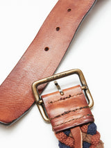 Close-up of the Pratese Belt - Brown by Blue de Gênes, crafted from vegetable tanned leather with braided detail and a brass buckle engraved with MADE IN ITALY. Two visible holes and meticulous stitching near the buckle highlight exquisite Italian craftsmanship.