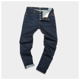 Blue de Gênes Repi Dai V Dark Jeans in dark blue denim are laid flat on a white surface. Made from comfort stretch fabric, they feature a button fly with visible buttons, rolled cuffs, and a light-colored lining on the interior waistband for style.