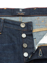 Close-up of Repi Dai V Dark Blue Denim Jeans by Blue de Gênes, showing a partially open button fly with four metallic buttons and a lighter denim lining inside the waistband. These regular slim-fit jeans are made from comfort stretch denim, with the brand label stitched on the waistband.