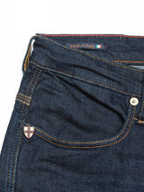 Close-up of Blue de Gênes Repi Dai V Dark Jeans in dark blue denim, featuring a shield emblem near the front pocket. The regular slim-fit waistband has a Made in Italy tag and an Italian flag, with contrast stitching accenting the comfort stretch design.