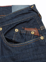 Close-up of Blue de Gênes Repi Dai V Dark Jeans in dark blue denim, highlighting the front and coin pockets. The regular slim-fit jeans feature comfort stretch for mobility, orange stitching, and brass rivets for style and reinforcement.