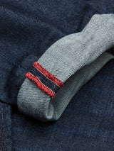 Close-up of rolled Repi Dai V Dark Jeans by Blue de Gênes reveals the inner seam. The dark blue denim features a lighter, textured side with red stitching, highlighting the craftsmanship and style of these regular slim-fit jeans made from comfort stretch fabric.