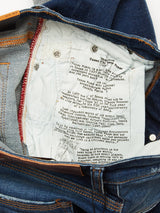 Inside view of Repi Dragon Dark Used Jeans reveals a printed interior about Genova Plaza, denim history, and Genovese traditions. Comfort stretch offers flexibility, while maroon stitching contrasts with denim blue. These are regular slim-fit jeans by Blue de Gênes.