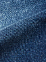 Close-up of Blue de Gênes Repi Dragon Dark Used Jeans in Denim Blue, featuring a diagonal seam. The texture displays varying blue shades and subtle wear, highlighting the comfort stretch denim typical of regular slim-fit jeans.