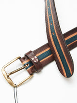 The Blue de Gênes Tino Belt - Brown Stripe is handmade in Italy from full-grain leather. It features brown, orange, and dark blue stripes with a brass buckle and a decorative cross emblem. The belt is shown partially coiled on a white background.