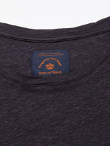 The collars label on the Totti T-Shirt - Dark Navy shows Progetto Heritage and Blue de Gênes in orange and red against a navy background. The close-up highlights the natural texture of its 100% linen jersey composition.