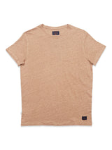 The Blue de Gênes Totti T-Shirt - Tuape is a plain beige short-sleeve round-neck tee made from linen jersey with a natural texture. It has a small black logo patch near the bottom hem on the left side.