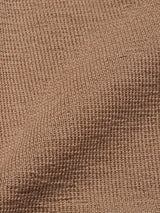 A close-up of the Zorba Knit Waistcoat - Taupe by Blue de Gênes showcases a textured brown fabric with a cozy, waffle-like pattern.