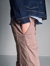 A person stands with one hand in their pocket, wearing Blue de Gênes Paulo Pavia 1 V2 Chino – Fungi, crafted from cotton stretch fabric. The photo is cropped from the chest down, highlighting this stylish and casual look.