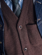 Close-up of a person wearing a dark green striped tie, light blue shirt, Blue de Gênes denim jacket, and the Blue de Gênes Koi Wool Gilet in Chocolate. The distinct layers and textures are clearly visible.