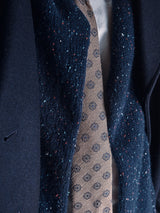 Close-up of a person wearing Blue de Gêness navy jacket and scarf, paired with the Nekutaki Tie #E – Sand Pattern, layered over a crisp white shirt—highlighting timeless tailoring.