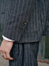 Close-up of a person in a Blue de Gênes Leopardi Dori Blazer with Italian cotton-wool blend gray stripes, highlighting the sleeves four dark buttons and a part of a ring on the hand, with the white shirt cuff showing beneath.