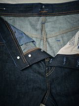 Discover the meticulous Italian craftsmanship of Blue de Gênes Giacomo Selvedge Jeans—Raw Denim. The dark blue rigid fabric showcases button and stitching details, while the lighter inner hue with visible seams and care label epitomizes timeless quality.