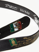 The Gari Belt - Black by Blue de Gênes is crafted from premium leather, featuring vibrant embroidered patches, including a crest and shield. It elegantly displays Dukes Finest Artisan and Handmade in Vienna in decorative white script.