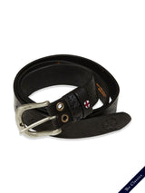 The Barra Belt - Black by Blue de Gênes features a coiled black cow leather design with a silver buckle, two rivets, and a small red and white emblem. It has embossed details and is set on a white surface with The Classics in the navy corner, offering a vintage style.