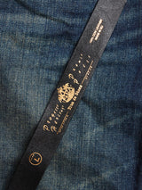 Close-up of the black Barra Belt by Blue de Gênes, featuring gold writing with Producers, Made exclusively for Blue de Genes in size L. Handmade stitches enhance the denims rich blue and vintage vibe.