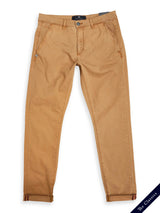 Teo Chino - Antique Bronze by Blue de Gênes: Vintage-look beige chinos featuring a button and zipper closure, front pockets, and rolled cuffs. A small decorative emblem on the pocket adds charm, while The Classics label graces the bottom corner.